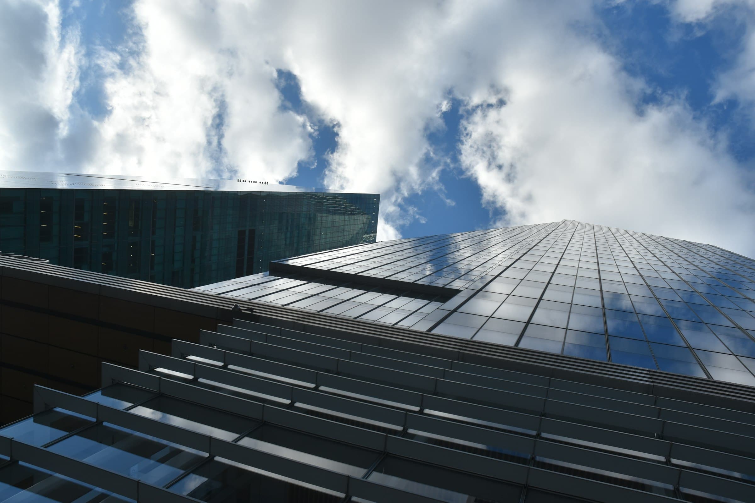 Glass office towers stacked in layers, seen from street level
